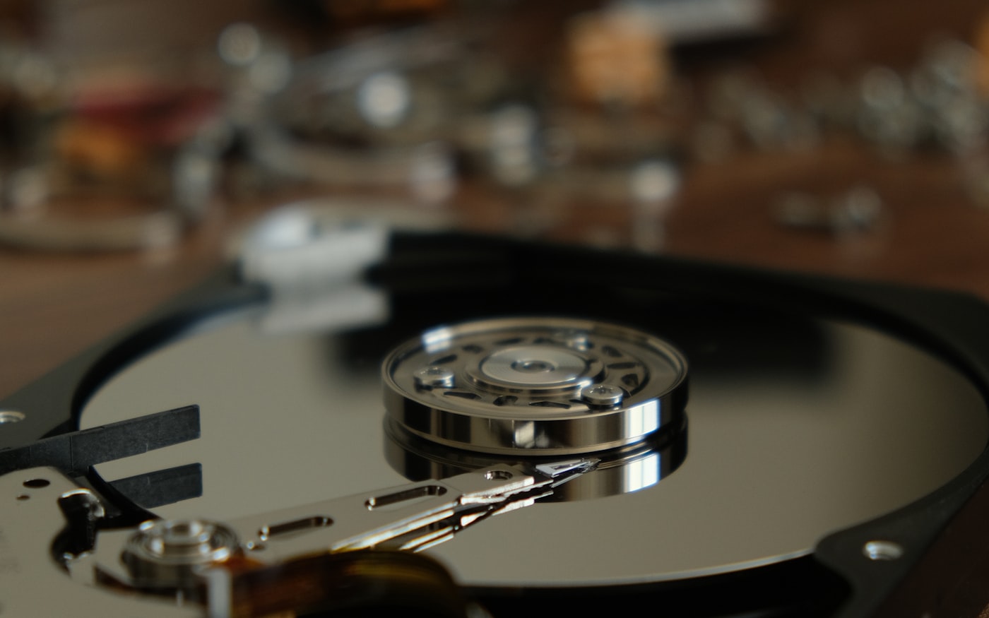An opened drive: platter, spindle and actuator arm in shallow focus.